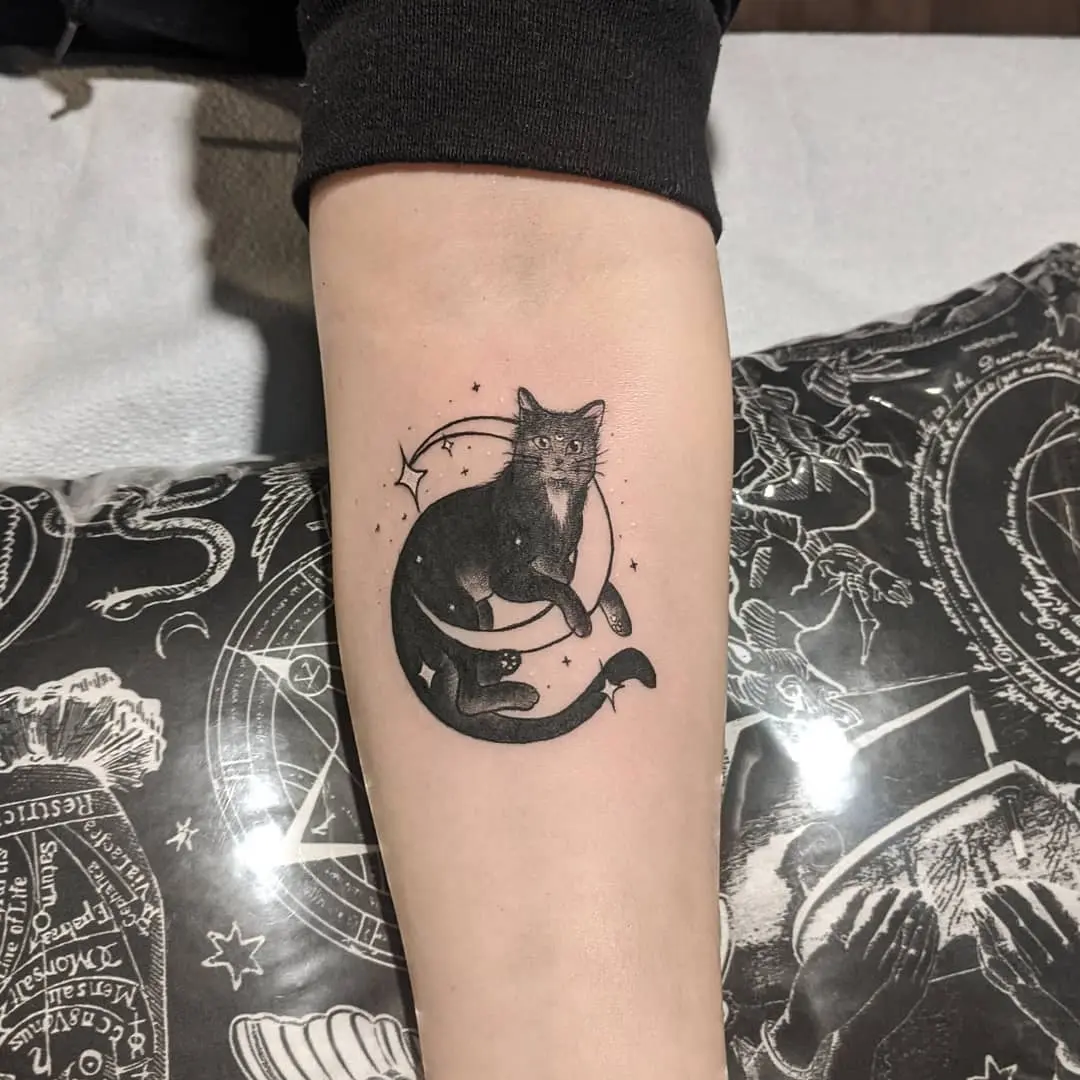 Charming black cat tattoo with celestial elements