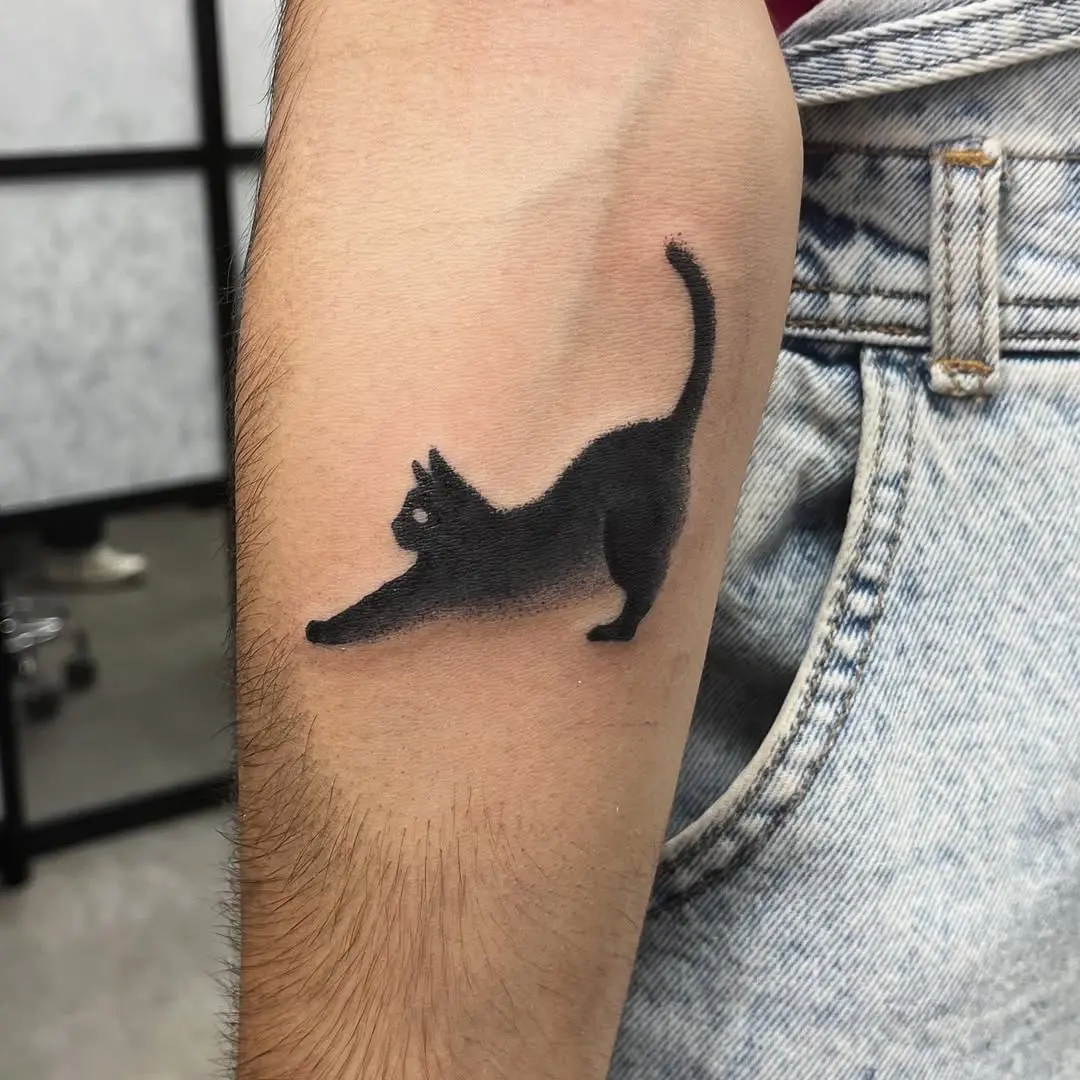 Elegant black cat tattoo in a stretching pose