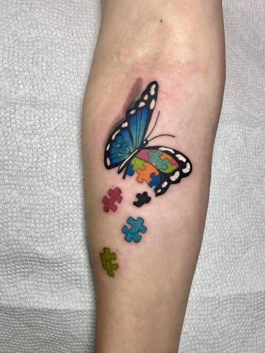 Symbolic butterfly tattoo with puzzle pieces
