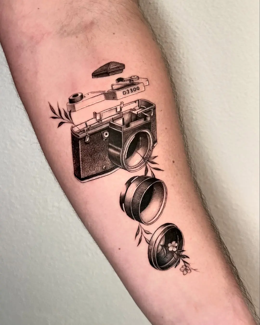 Intricate camera tattoo design with floral elements