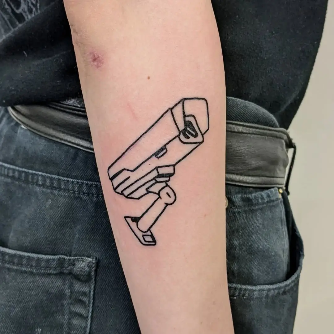 Minimalistic camera tattoo on forearm