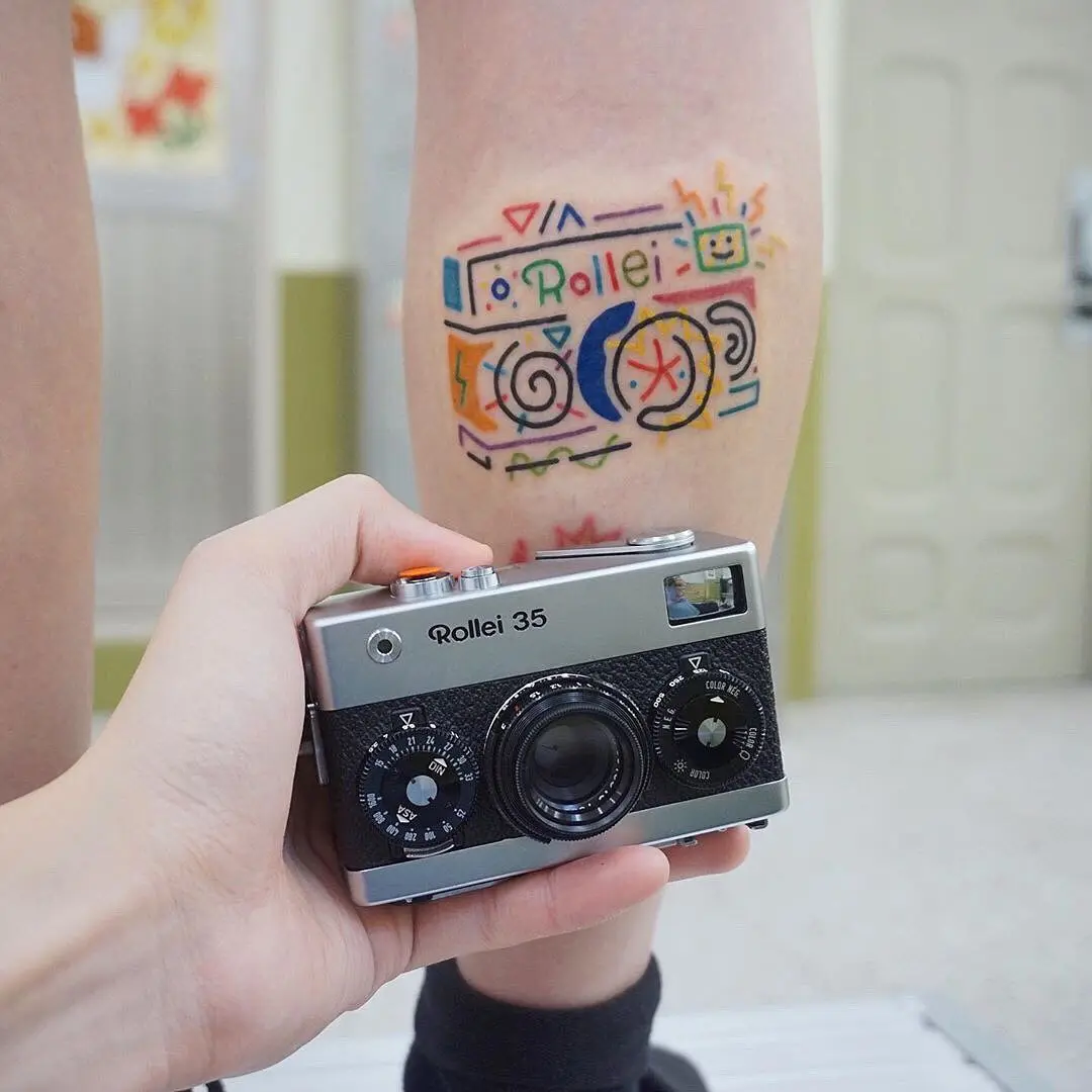 Colorful camera tattoo with playful designs