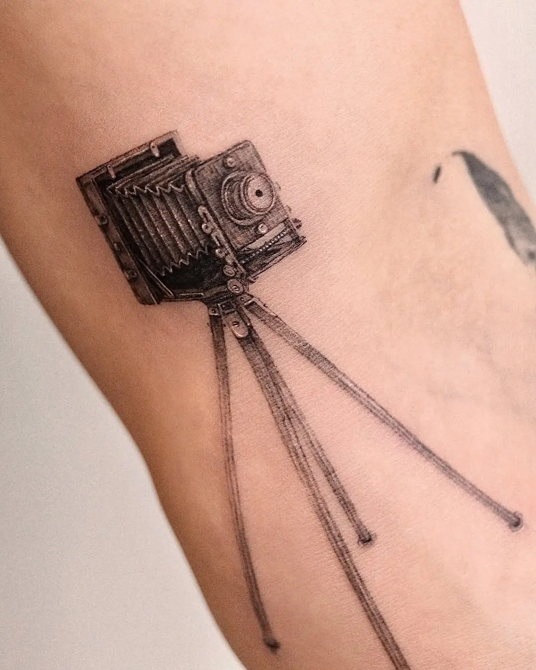 Intricate vintage camera tattoo on the arm