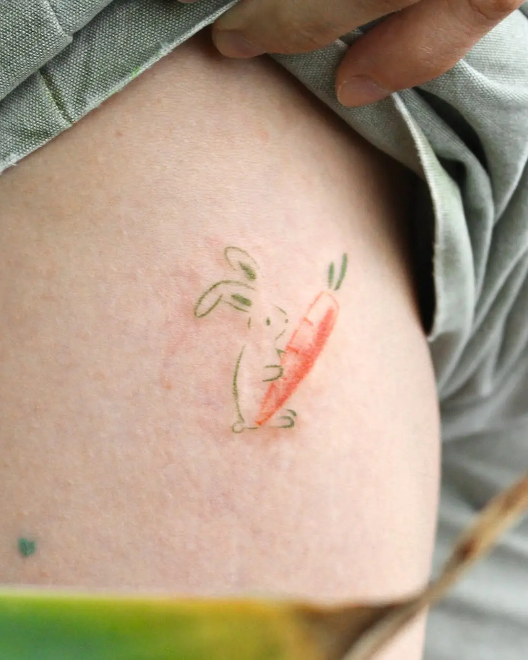 Charming rabbit holding a vibrant carrot tattoo
