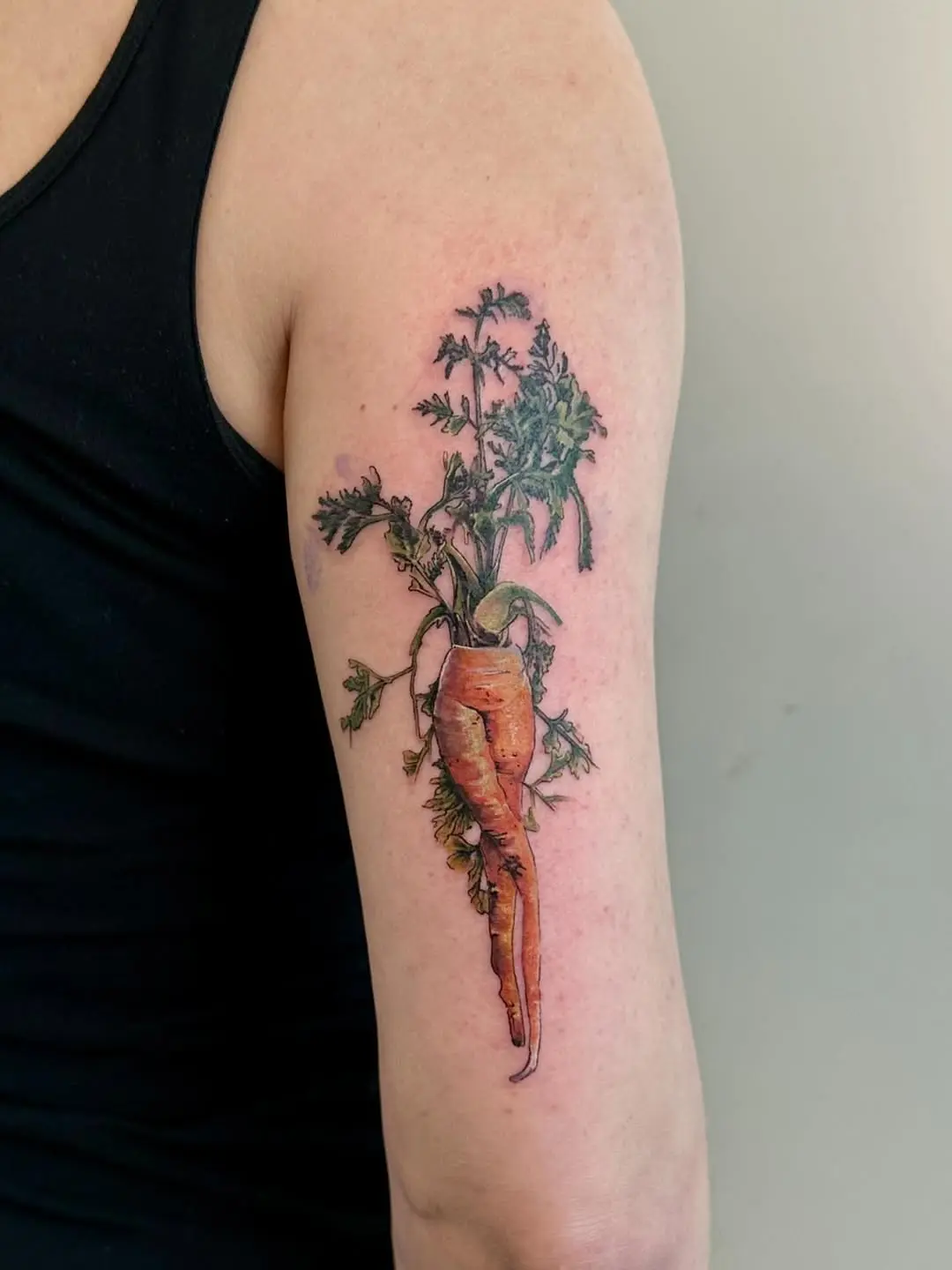 Intricate carrot tattoo with leafy greens