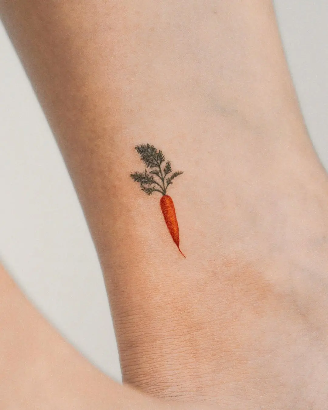 Charming minimalist carrot tattoo on ankle