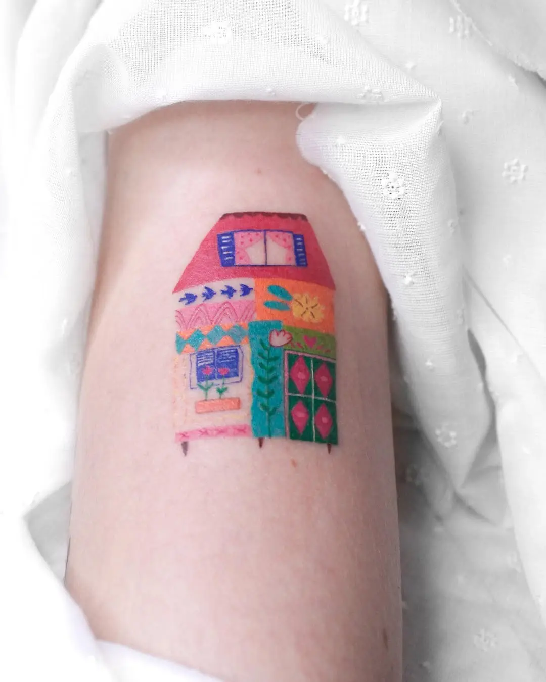 Vibrant house tattoo with playful colors