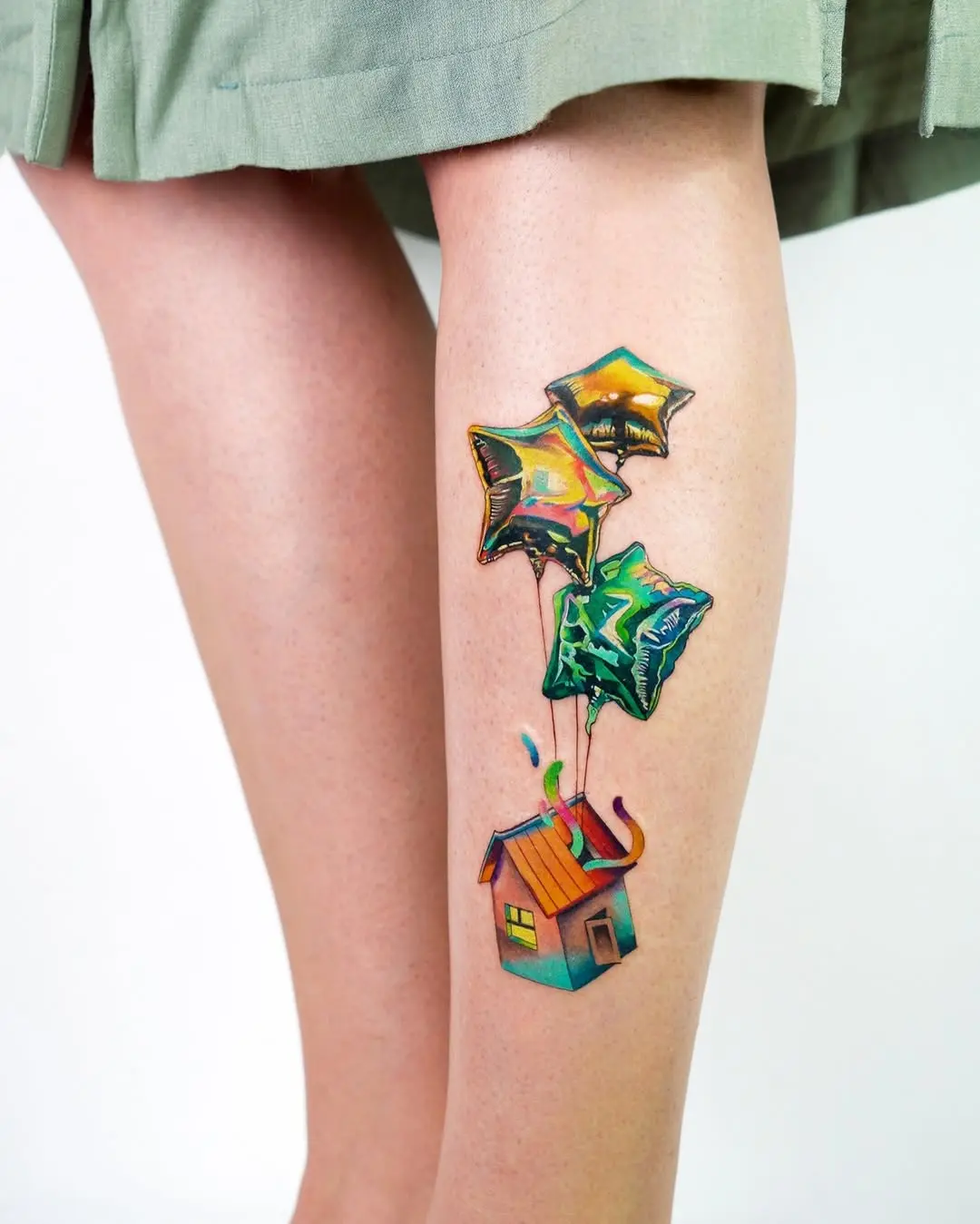 A whimsical house tattoo with vibrant balloons
