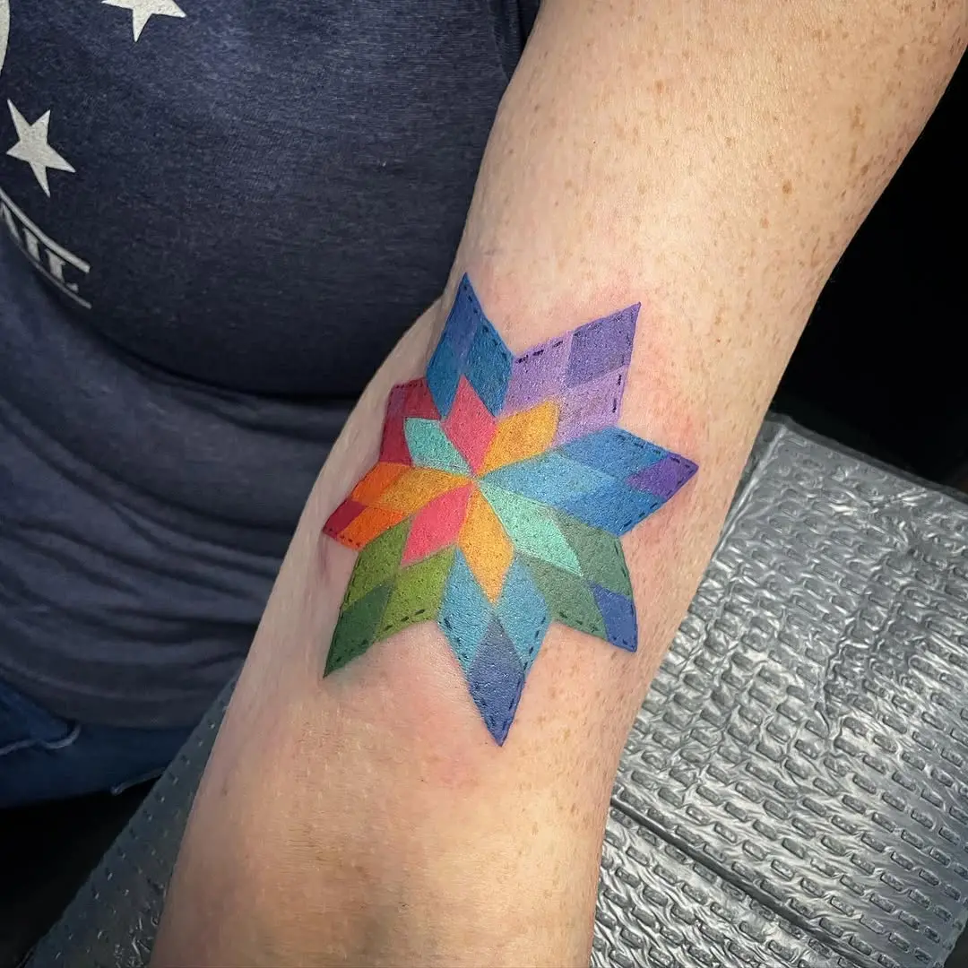 Vibrant geometric quilt tattoo on the arm