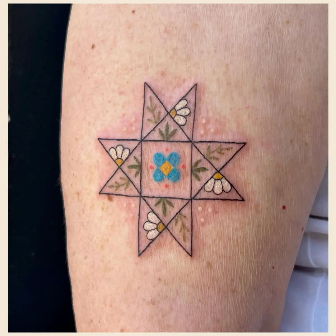 Charming quilt star tattoo with floral accents