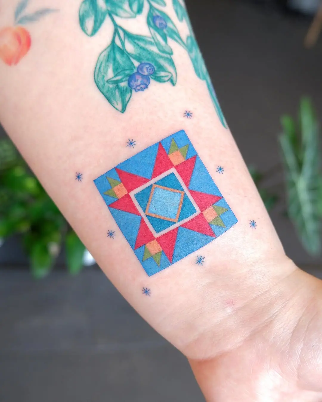 Vibrant quilt star tattoo on forearm