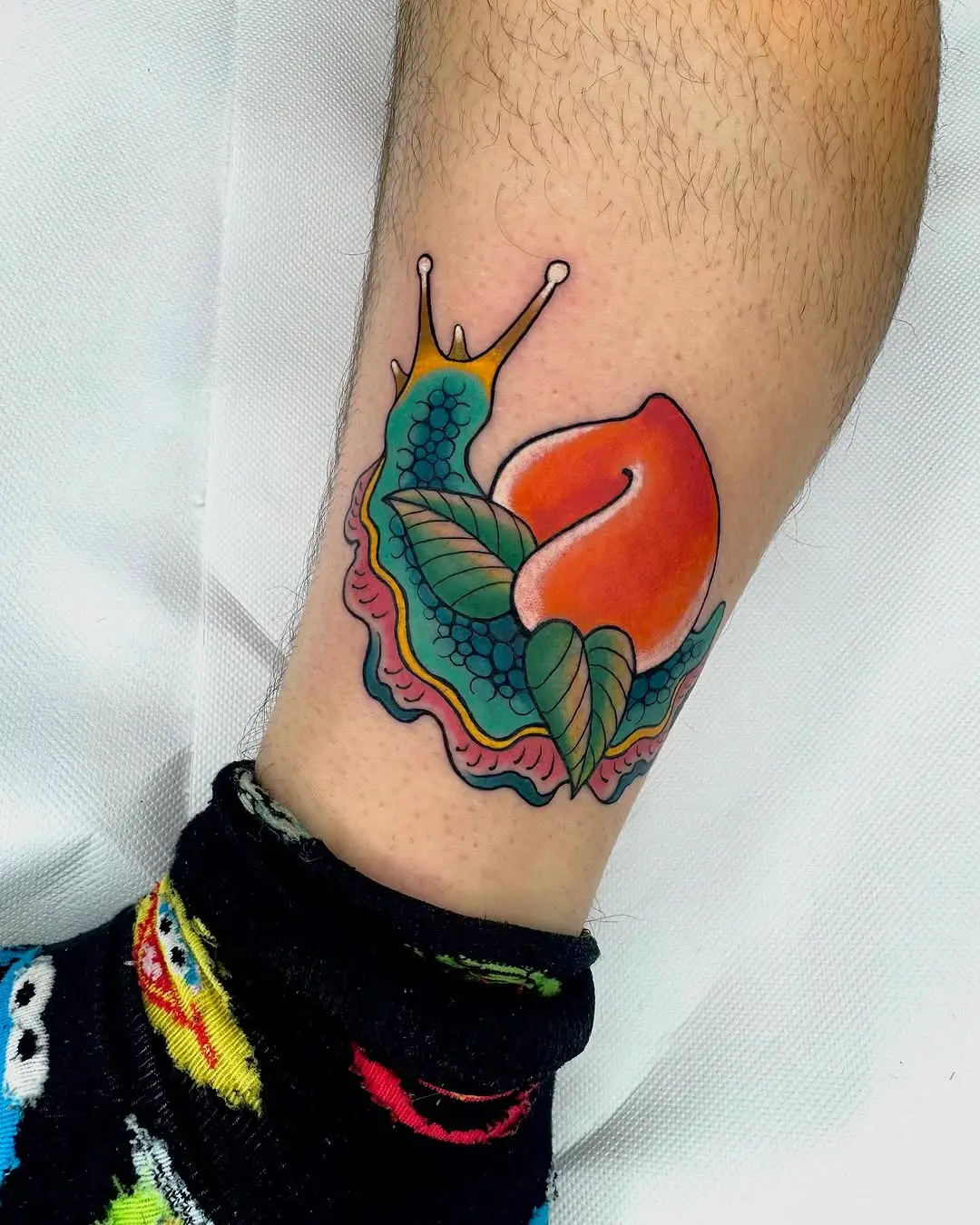Vibrant snail tattoo with a peach design