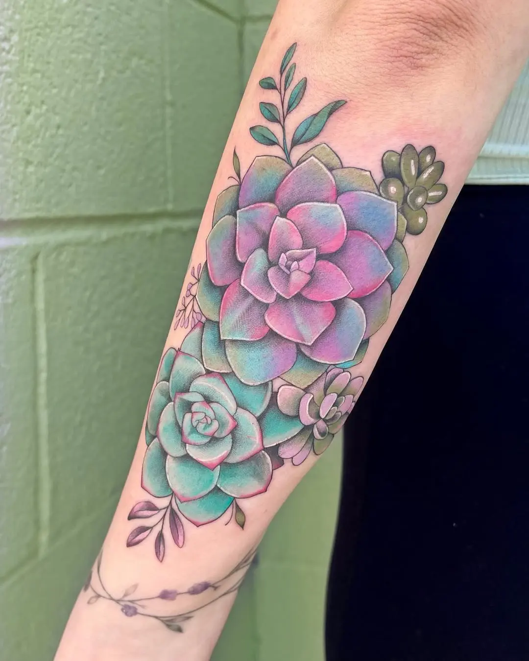 Vibrant succulent tattoo with delicate foliage accents