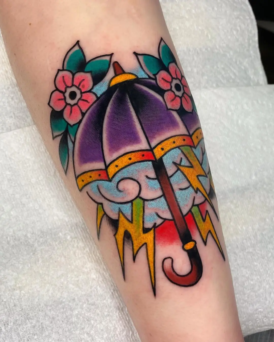 Vibrant umbrella tattoo with floral elements
