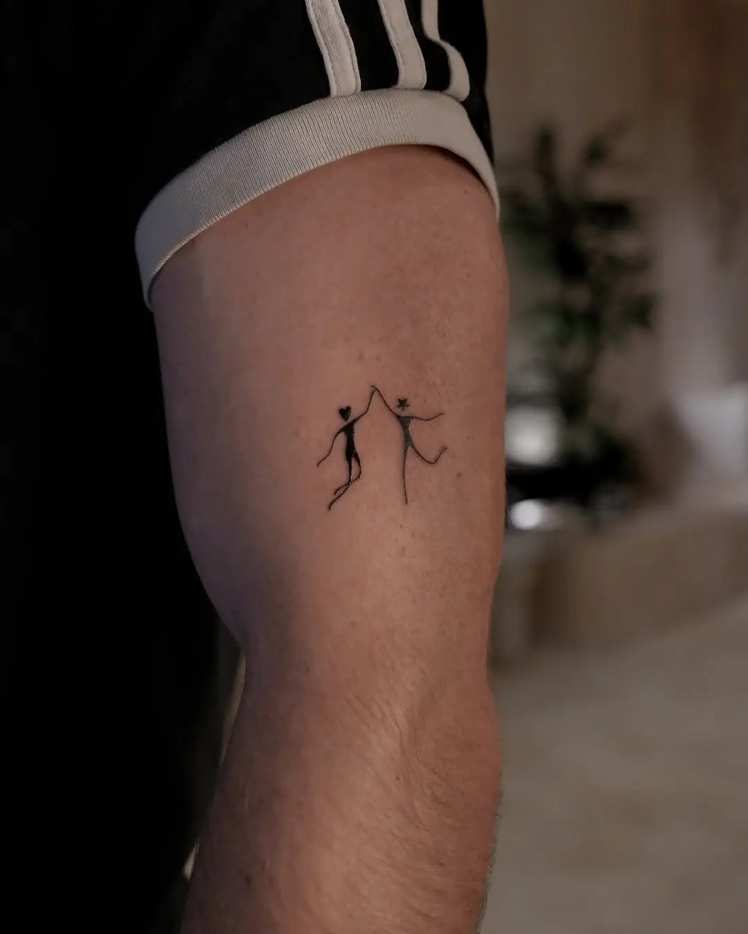 Two figures celebrate unity through dance tattoos.