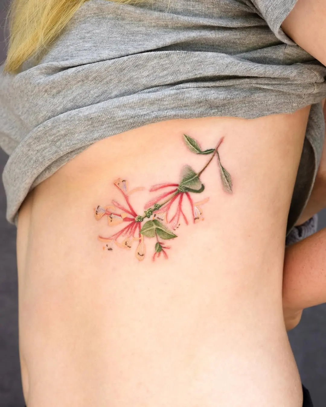 Elegant honeysuckle tattoo blooming on the side