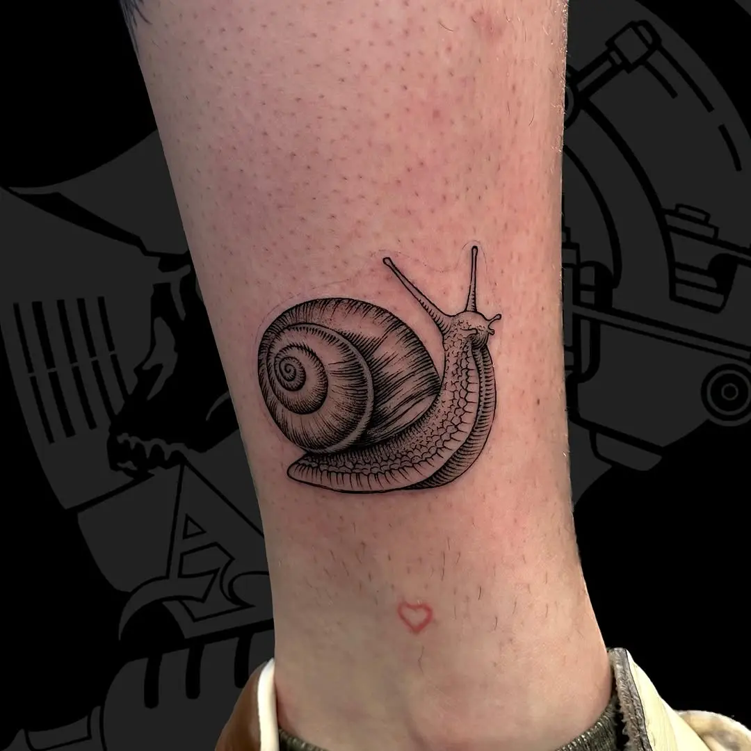 A unique black snail tattoo for enthusiasts