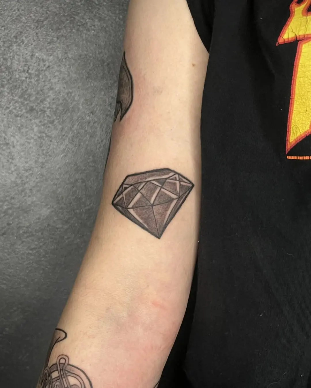 Minimalist diamond tattoo on the arm