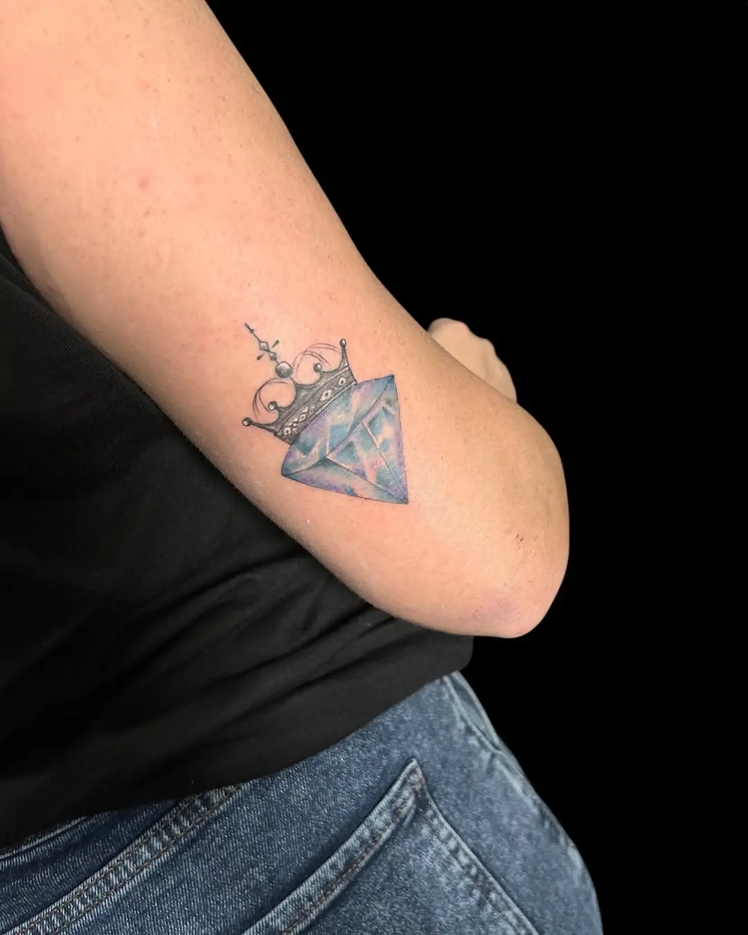 Stunning crown-adorned diamond tattoo on arm