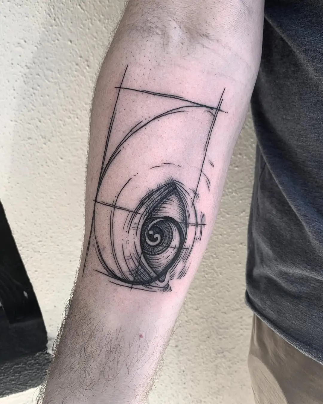Intricate Fibonacci spiral tattoo design on forearm.