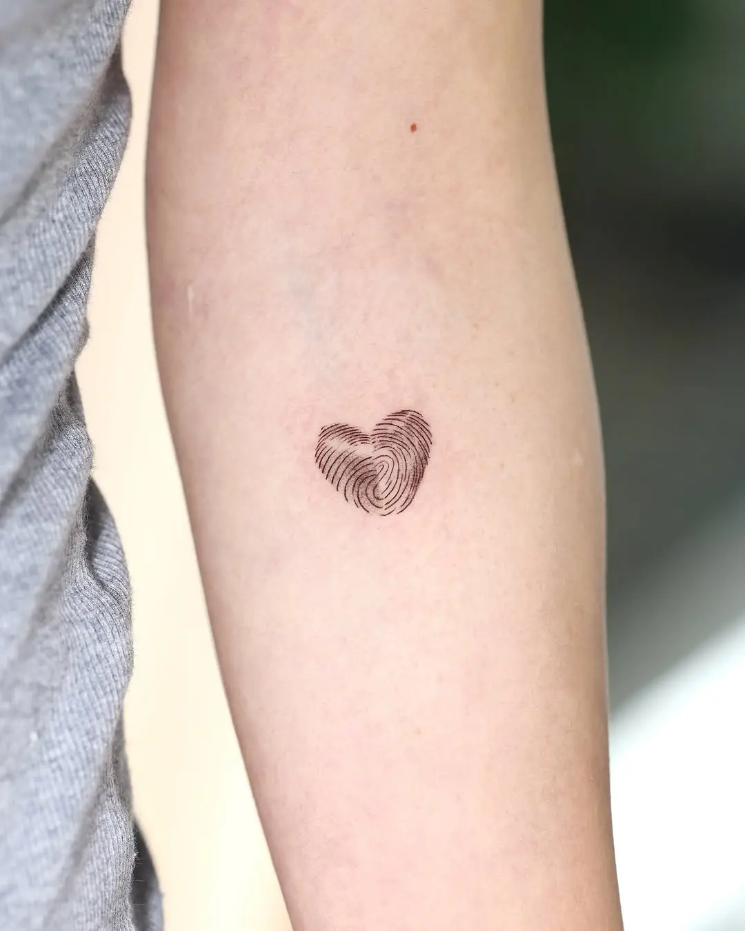 Stylish heart-shaped fingerprint tattoo on arm