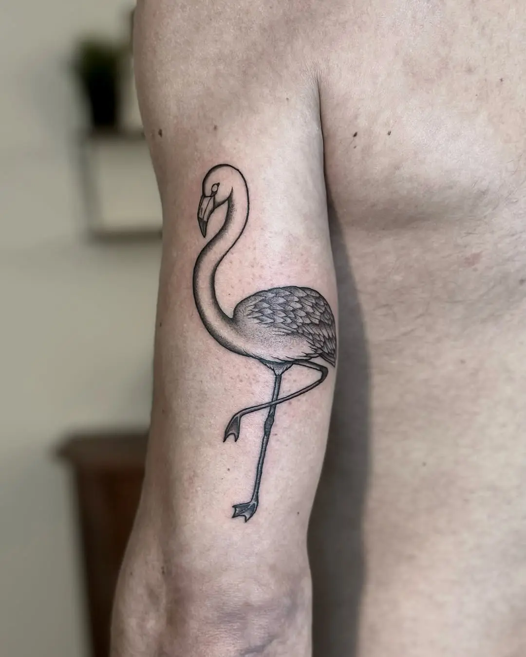 Stylish flamingo tattoo on muscular arm