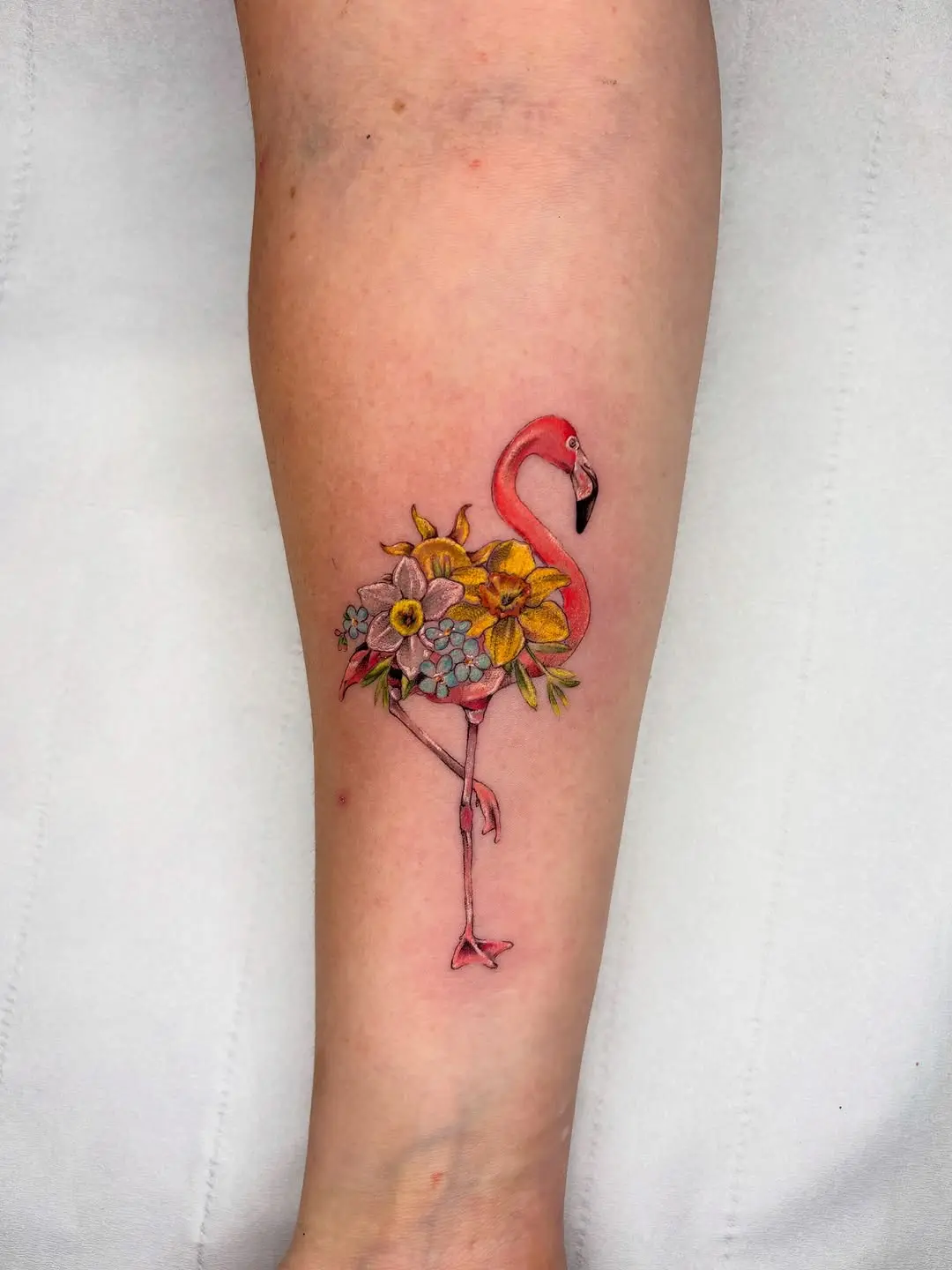 Whimsical flamingo tattoo adorned with flowers