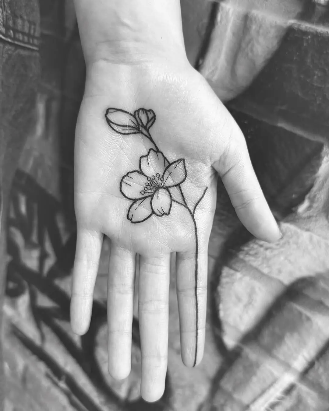 Delicate floral design on palm tattoo