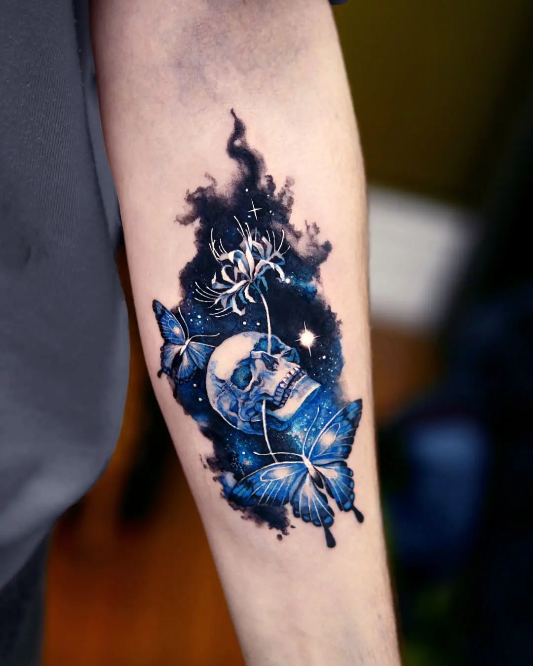 Stunning galaxy-inspired skull and butterfly tattoo.