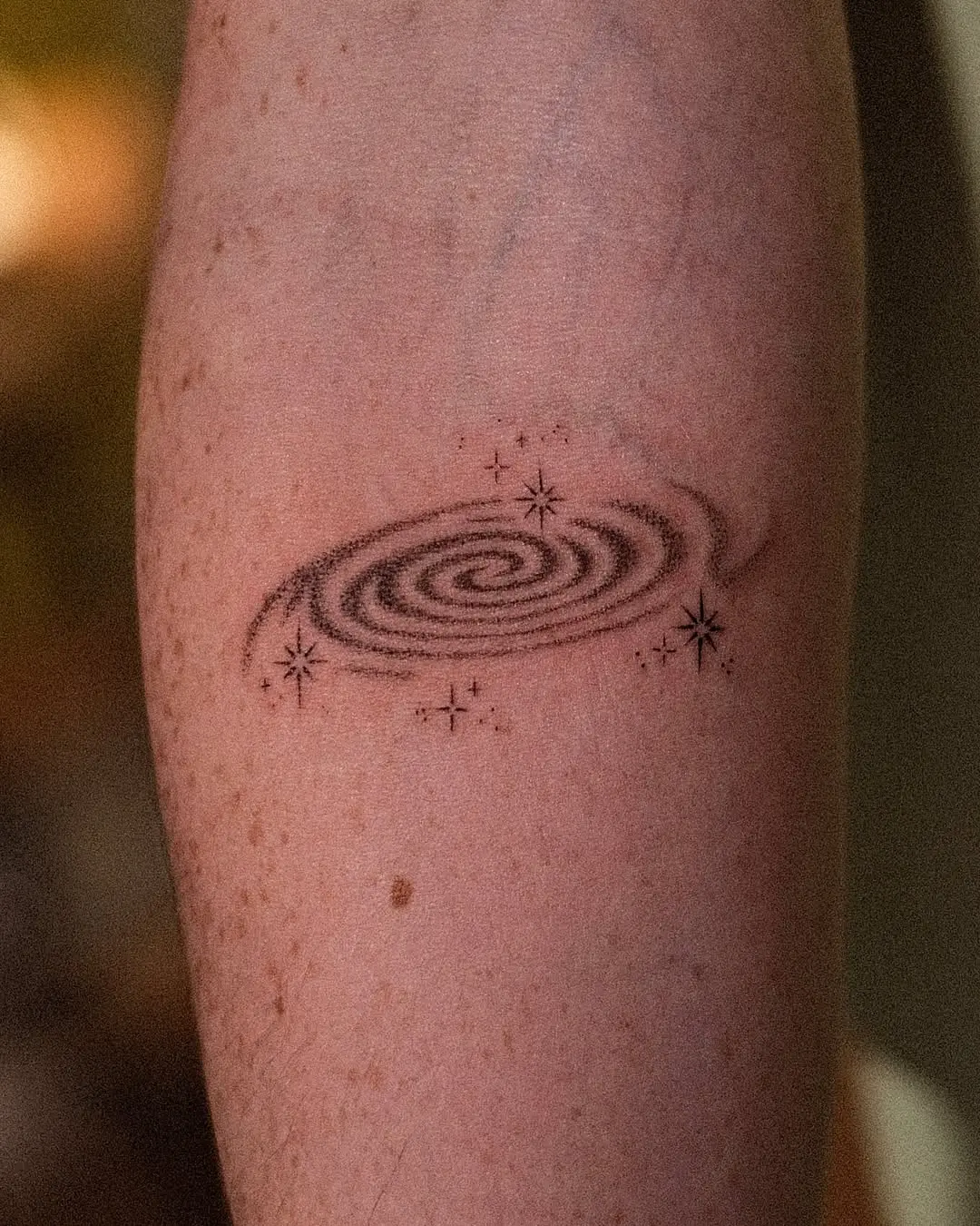 Intricate galaxy swirl tattoo with star accents