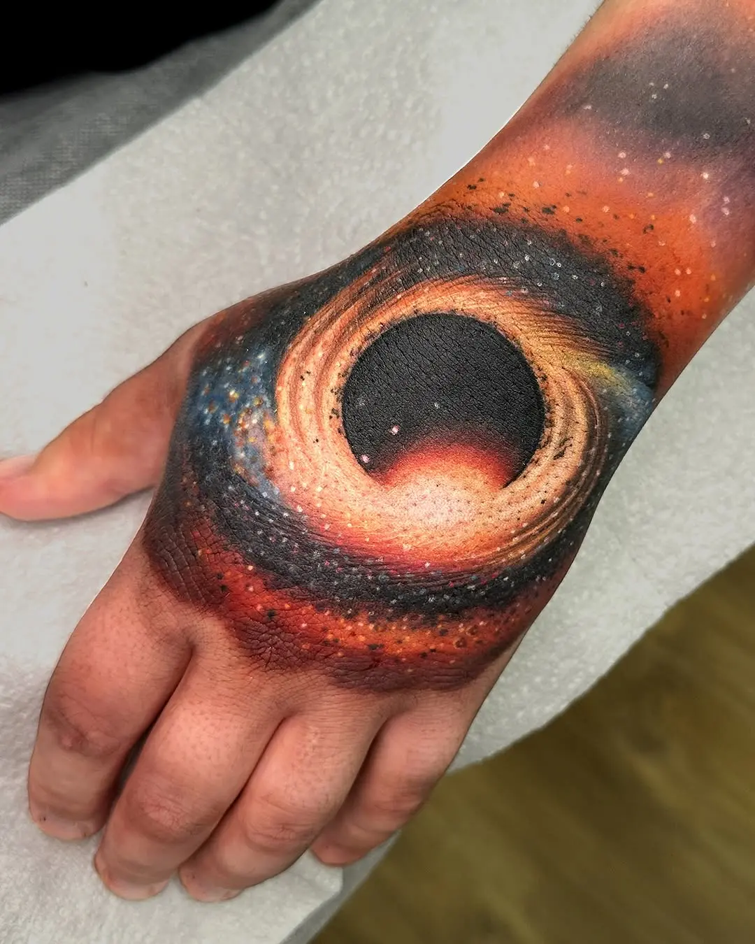 Mesmerizing hand tattoo of a black hole