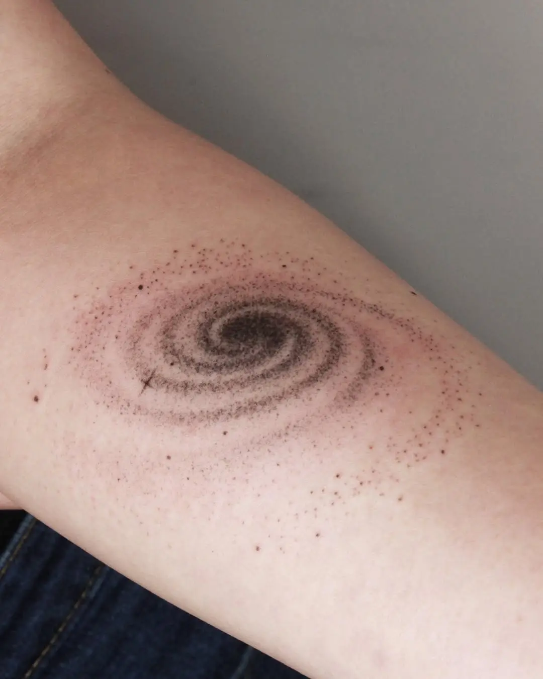Stunning spiral galaxy tattoo design on forearm