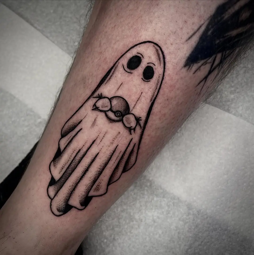 Whimsical ghost tattoo holding a Pokéball