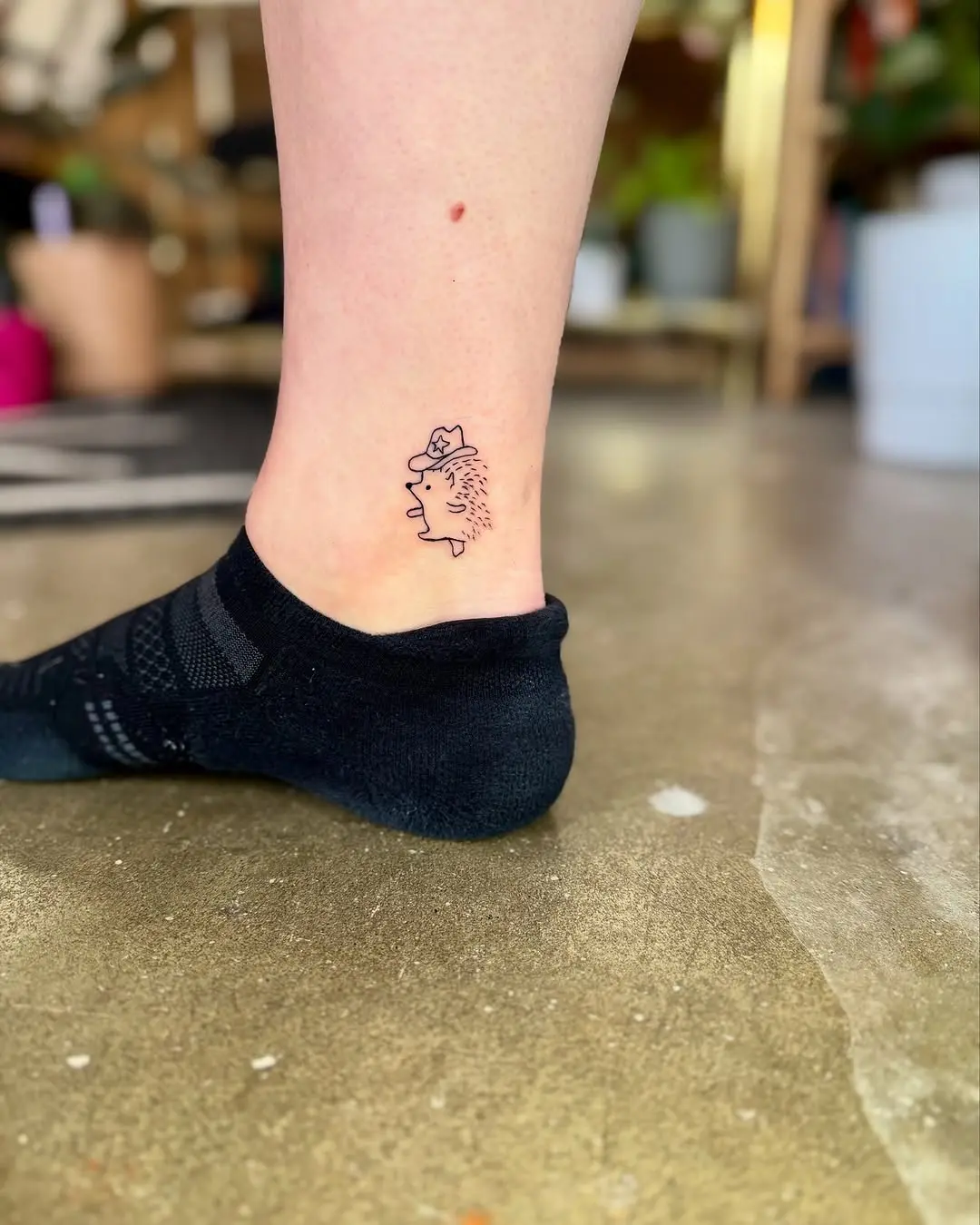Charming and playful hedgehog tattoo on ankle.