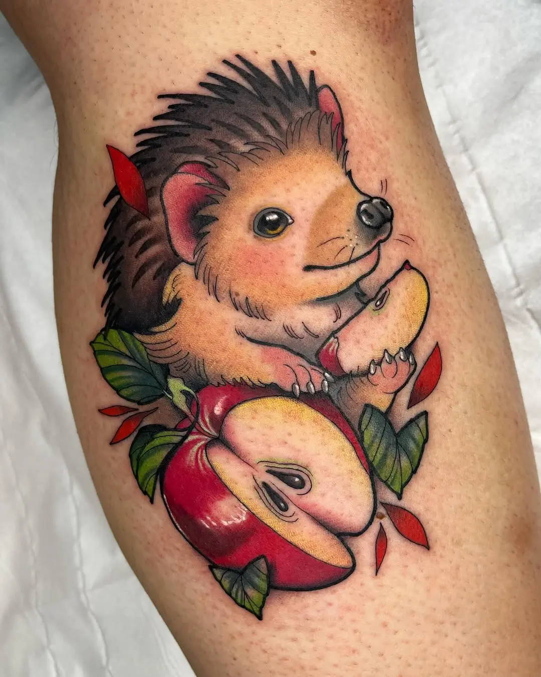 Charming hedgehog tattoo embracing fresh apples