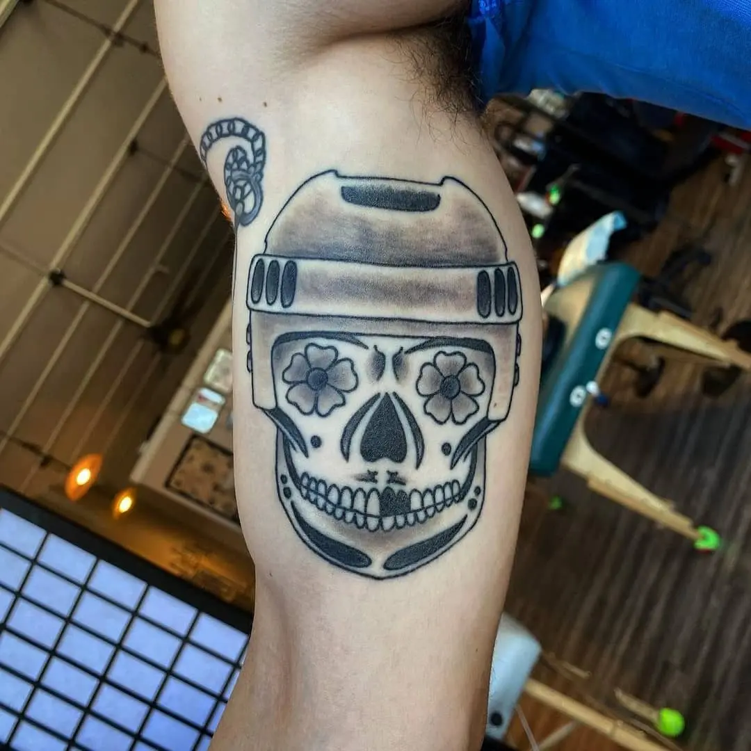Unique hockey-themed skull tattoo with flowers