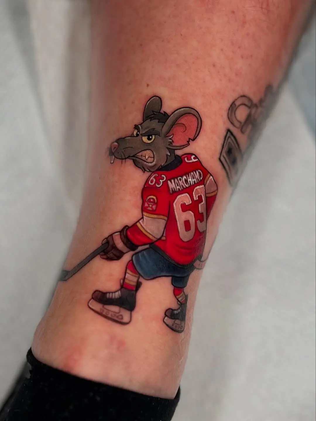 Whimsical hockey rat tattoo brings playful energy