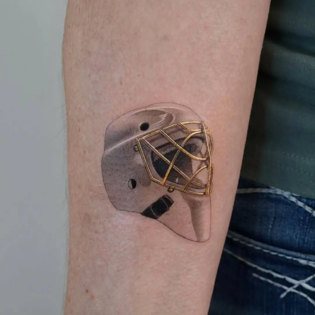 Intricate goalie mask tattoo showcasing artistry.