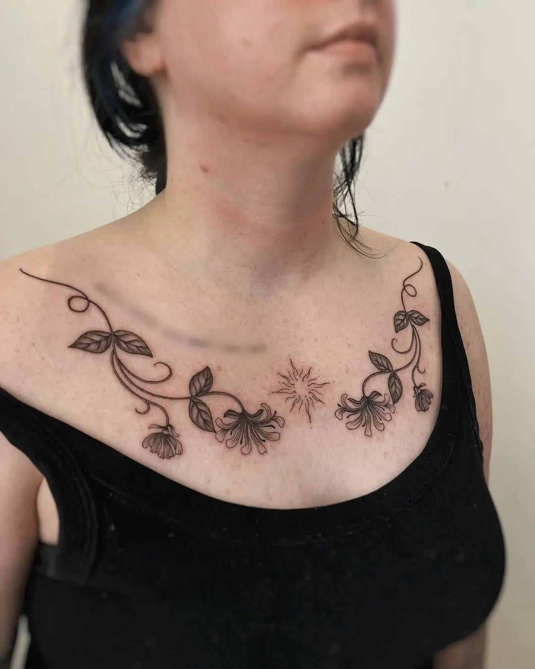Delicate honeysuckle tattoo across the chest