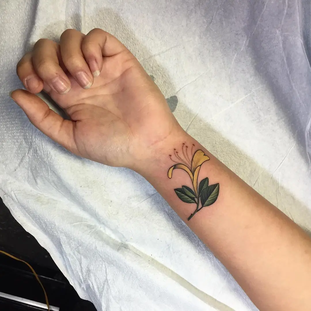 Elegant honeysuckle tattoo on the wrist.