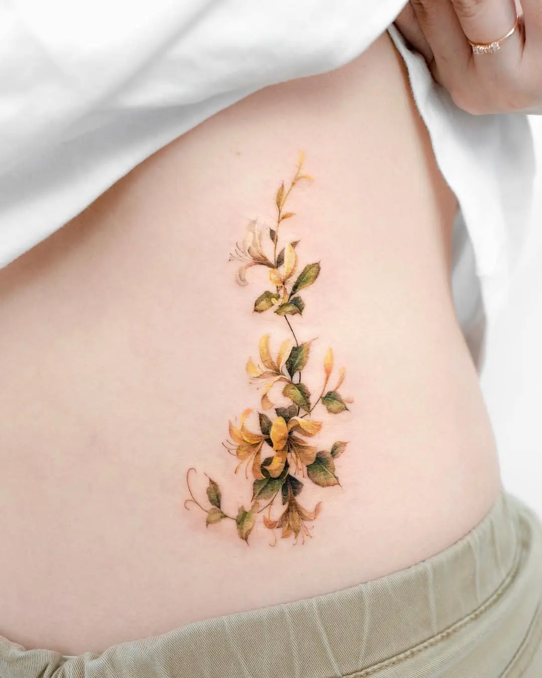 Stunning honeysuckle tattoo on the rib cage