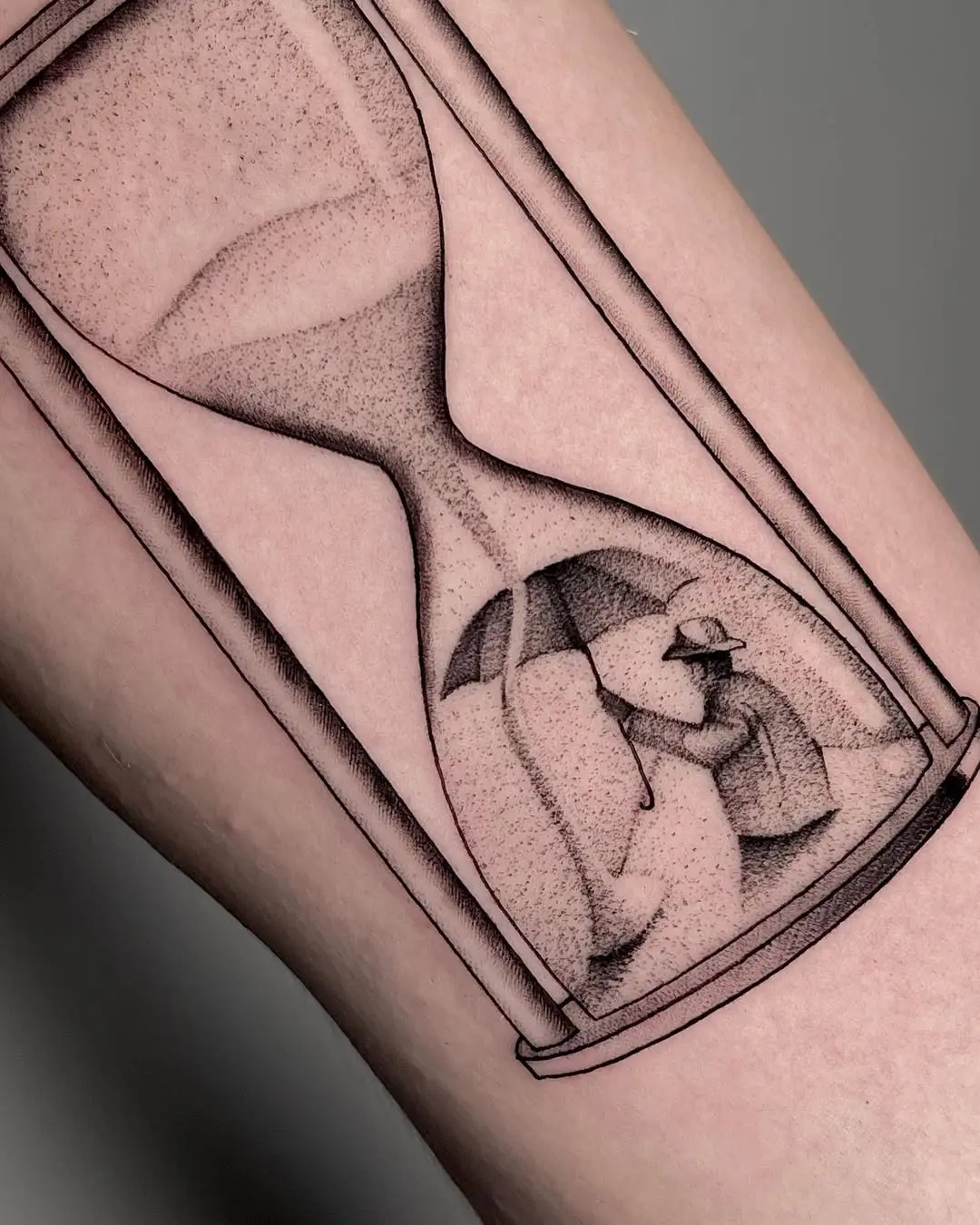 Symbolic umbrella within an hourglass tattoo