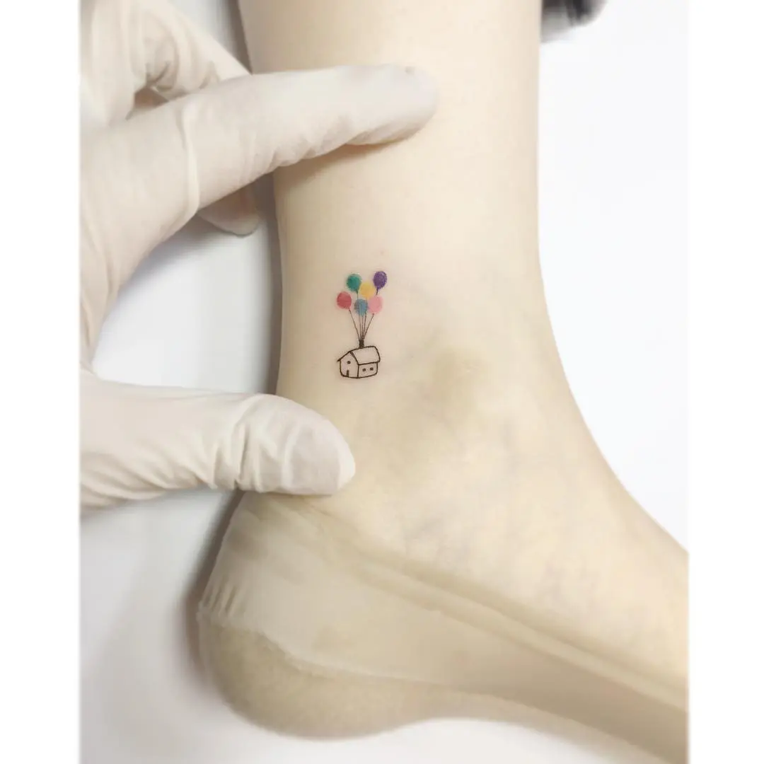 Charming house tattoo with colorful balloons