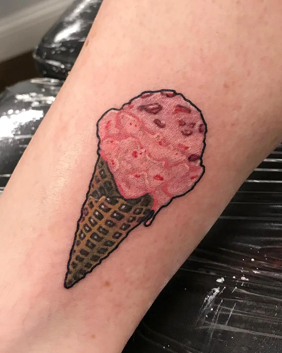 Charming pink ice cream cone tattoo on skin