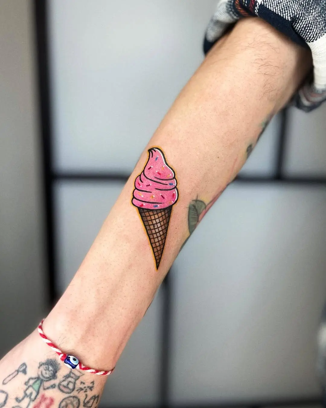 Charming ice cream cone tattoo on forearm