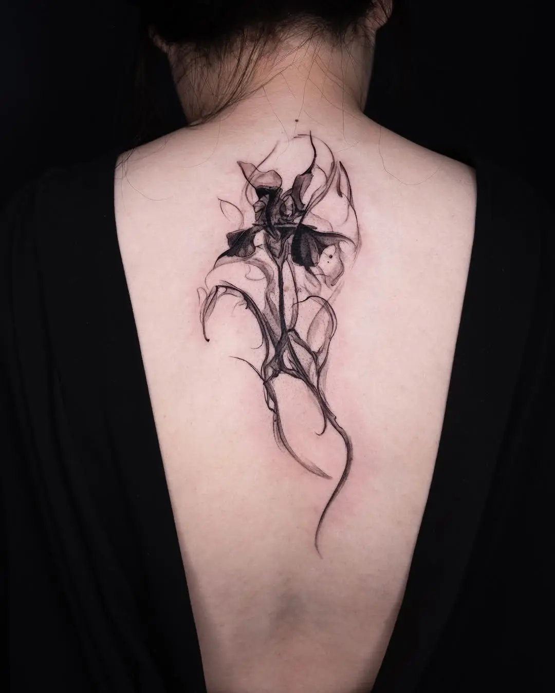 Elegantly intricate iris tattoo on the back
