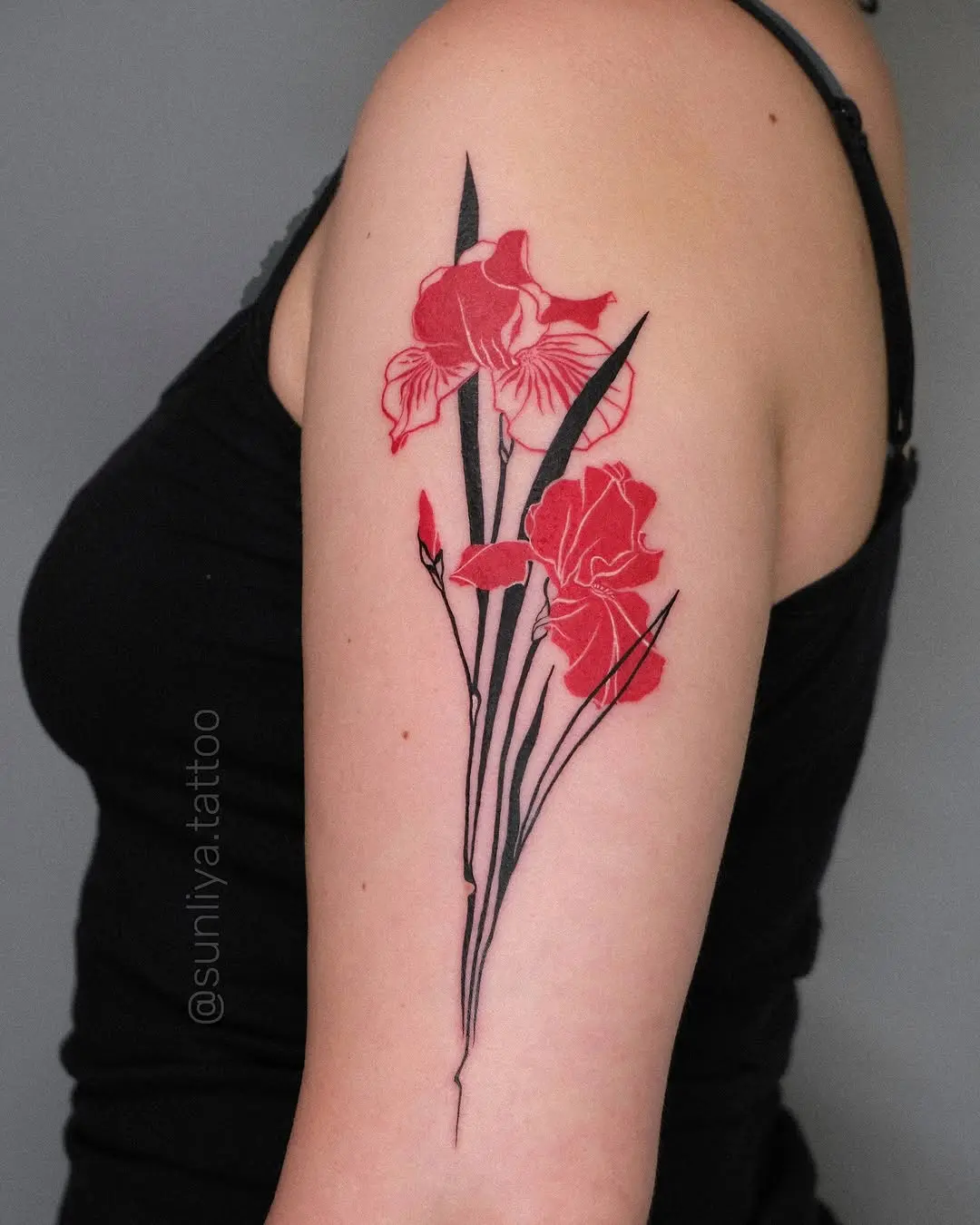 Stunning vibrant iris tattoo on the upper arm.