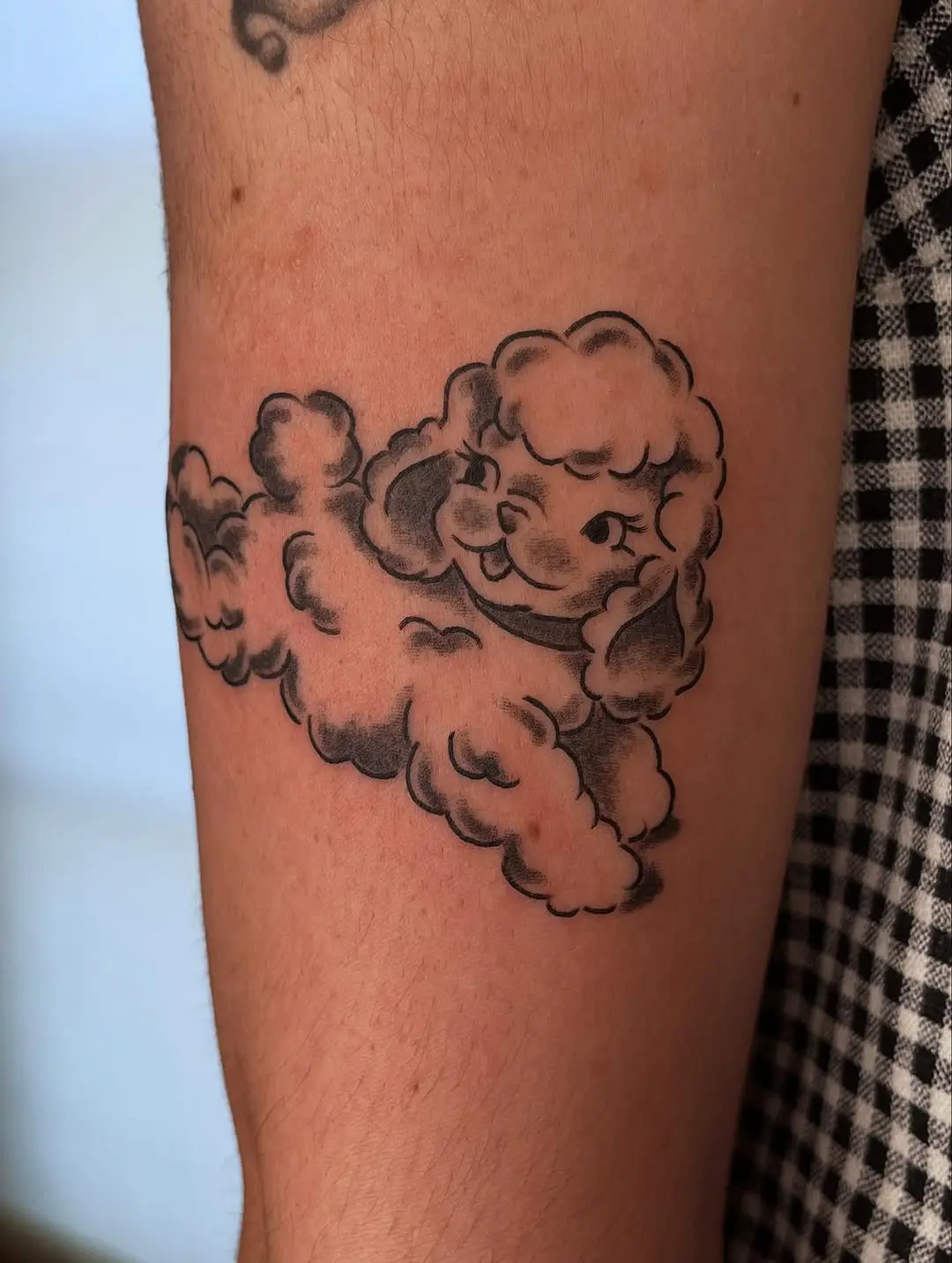 Playful lamb tattoo with cloudy vibes
