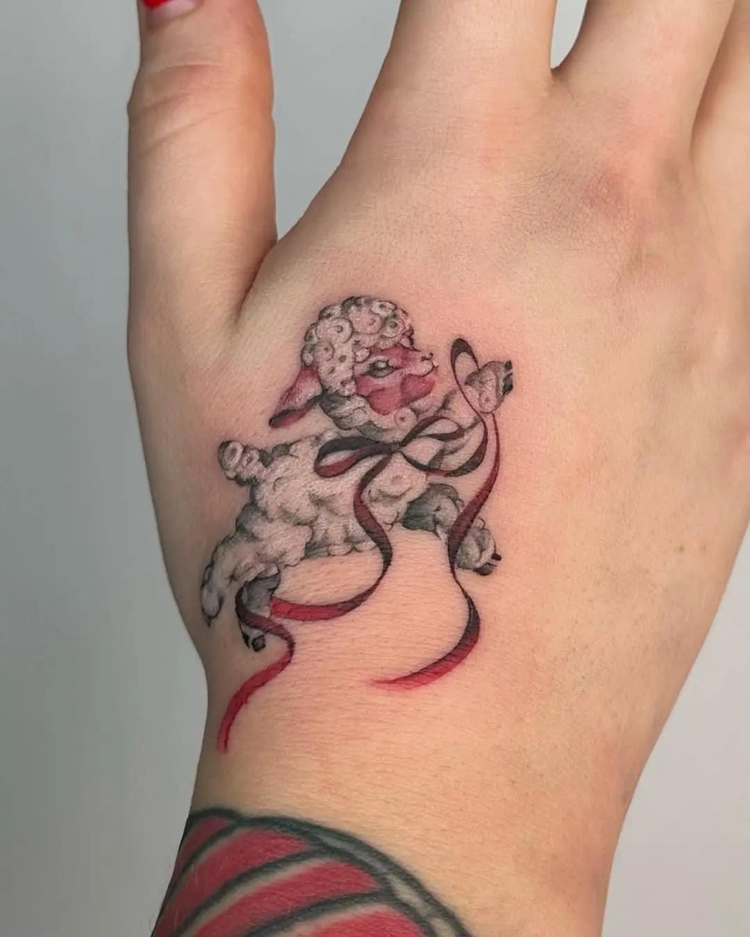 Whimsical lamb tattoo with playful elements