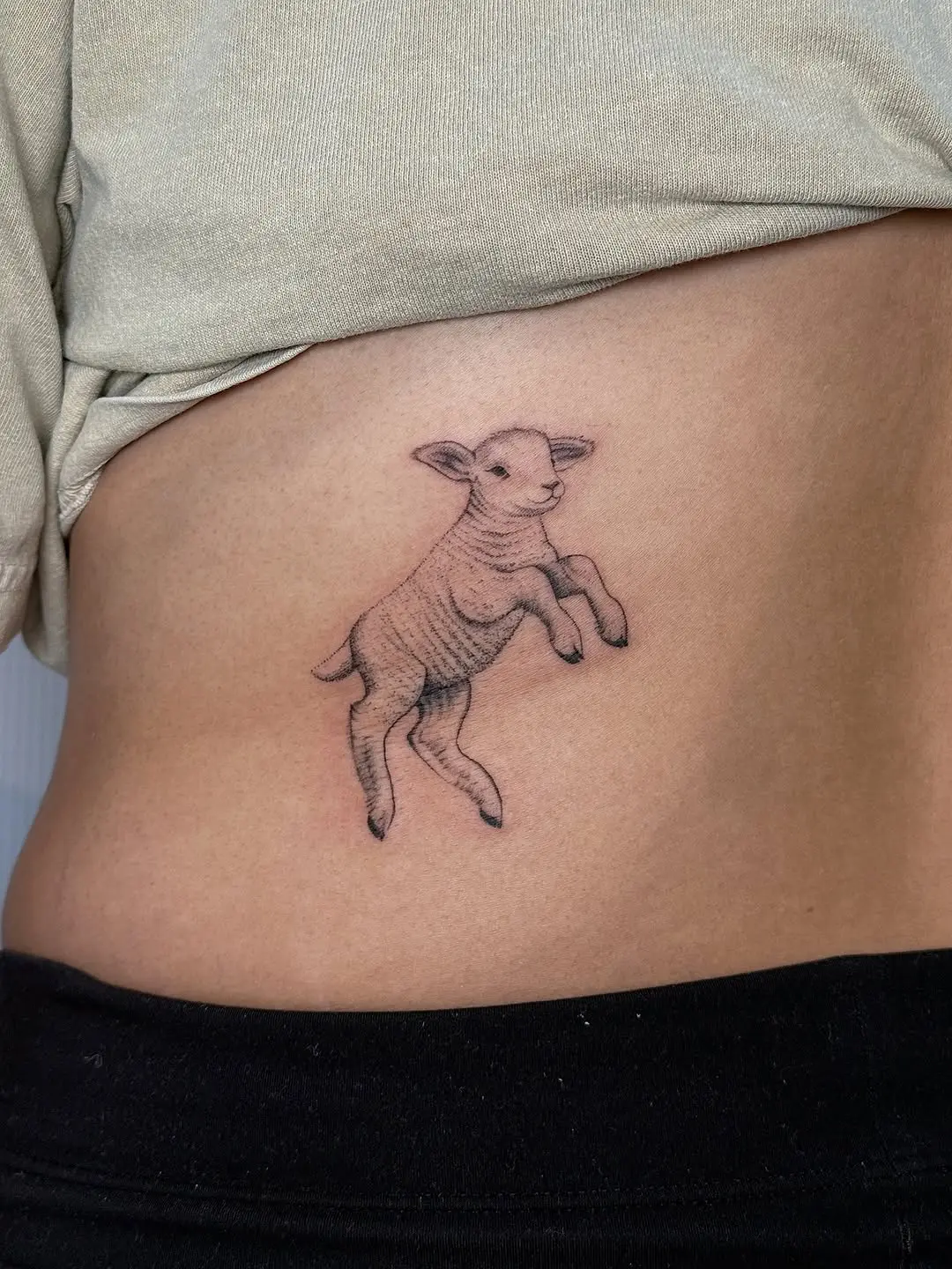 Whimsical jumping lamb tattoo for body art